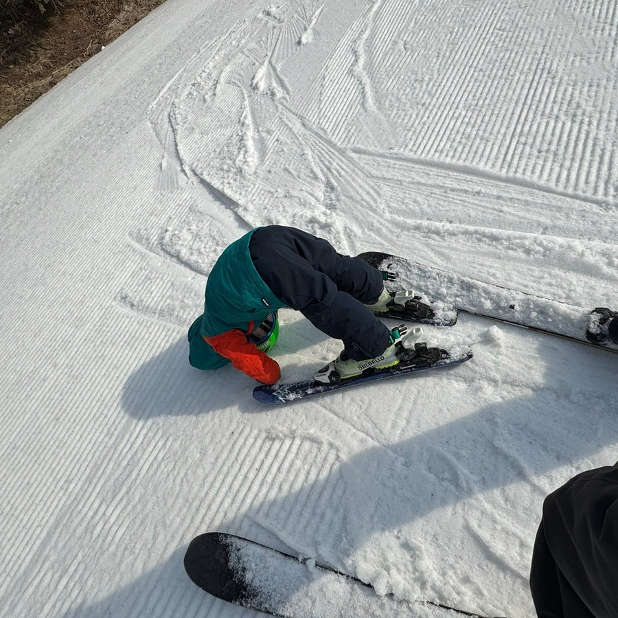 toddler skier having a tough time learning to ski for the first time.